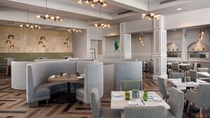 A modern restaurant with booth seating, pendant lighting, and a herringbone wood floor. - MarBrisa Carlsbad Resort (Carlsbad)