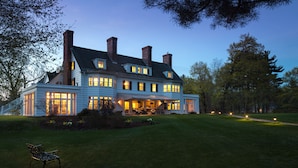 A large, two-story house with a covered porch and multiple chimneys. - The Four Chimneys Inn (Bennington)