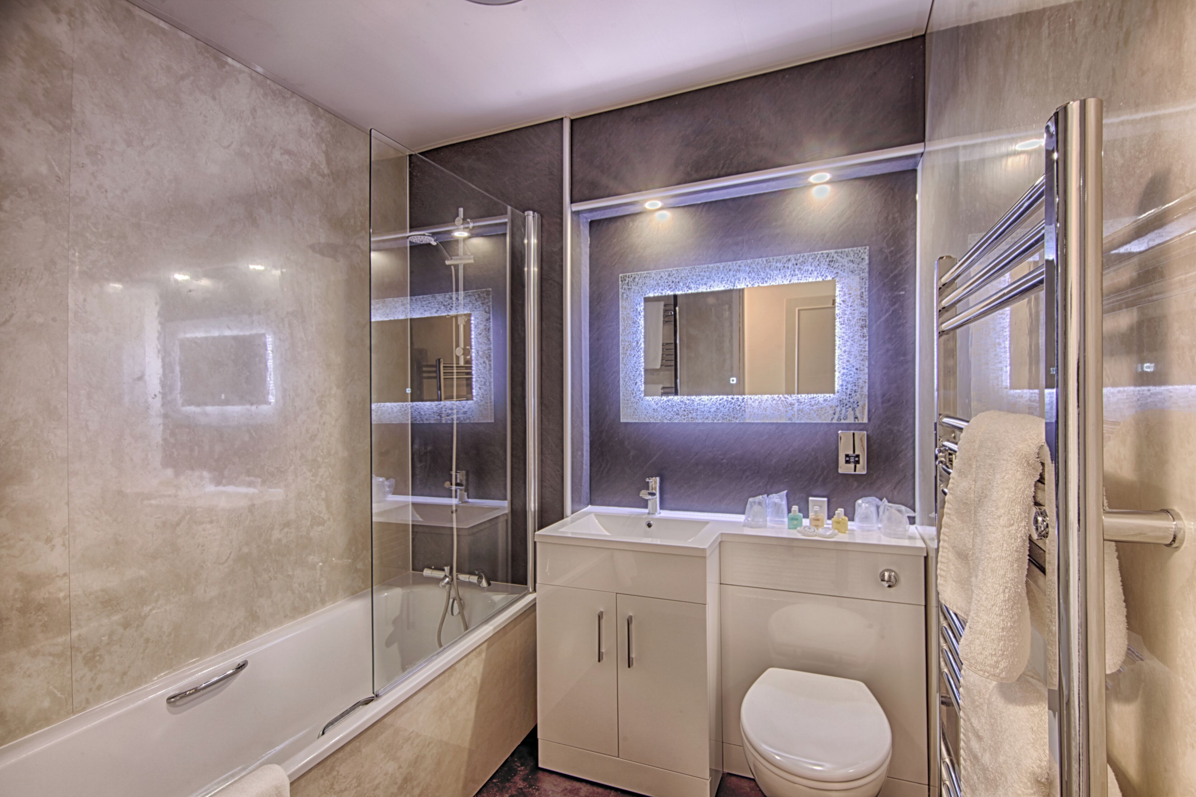 A modern bathroom with a glass-enclosed shower, a white sink, and a toilet.