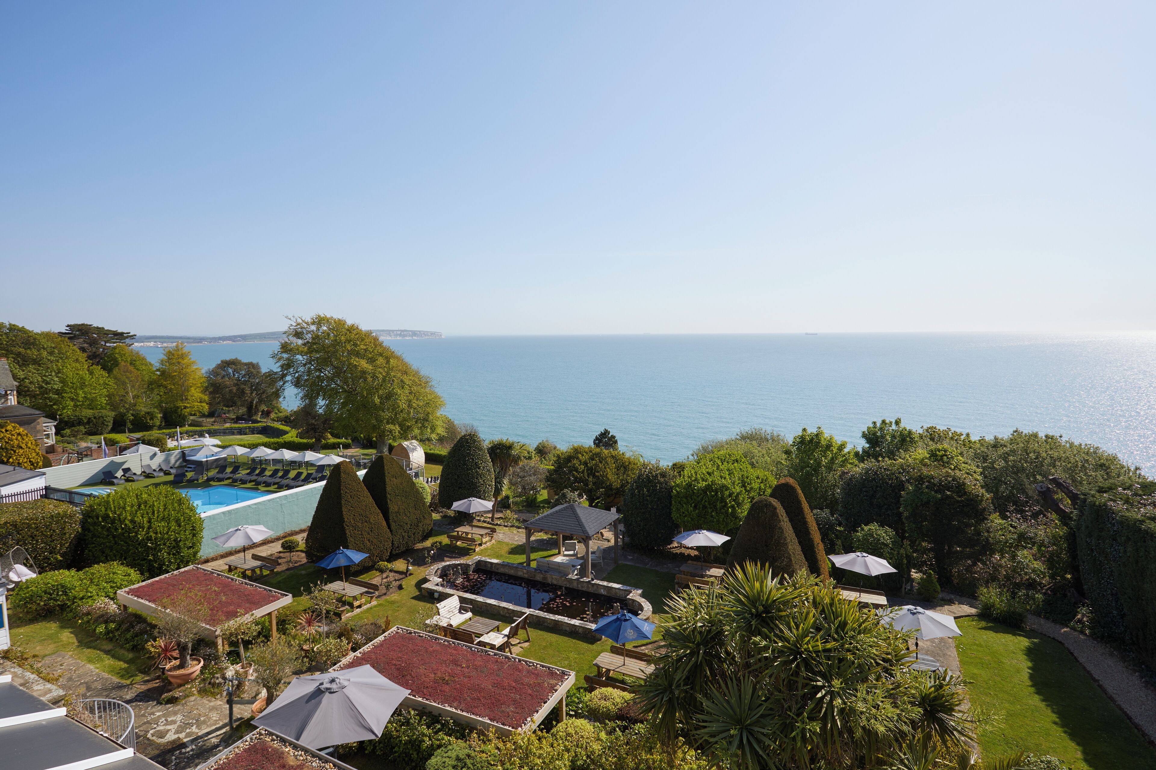 Ein Resort mit Swimmingpool, Liegestühlen und Meerblick.