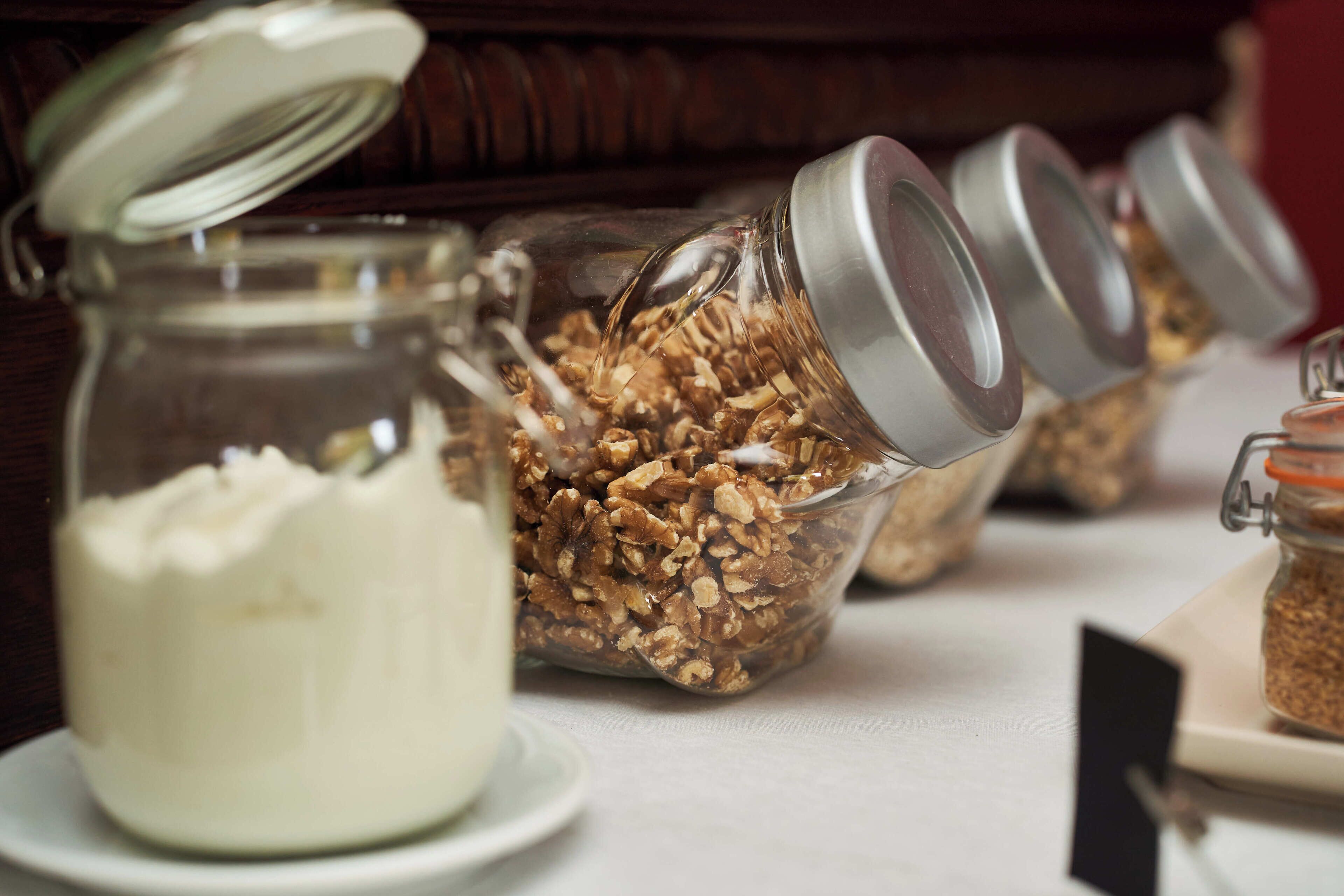 A table with jars of granola and yogurt.