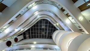 Un atrio de varios niveles con balcones curvos y un techo de vidrio central.