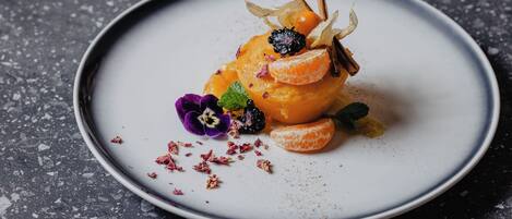 Un postre en un plato sobre un fondo oscuro moteado.