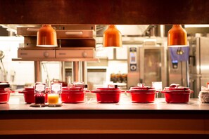 A kitchen with red cookware and overhead lighting. - Copperhill Mountain Lodge (Are)