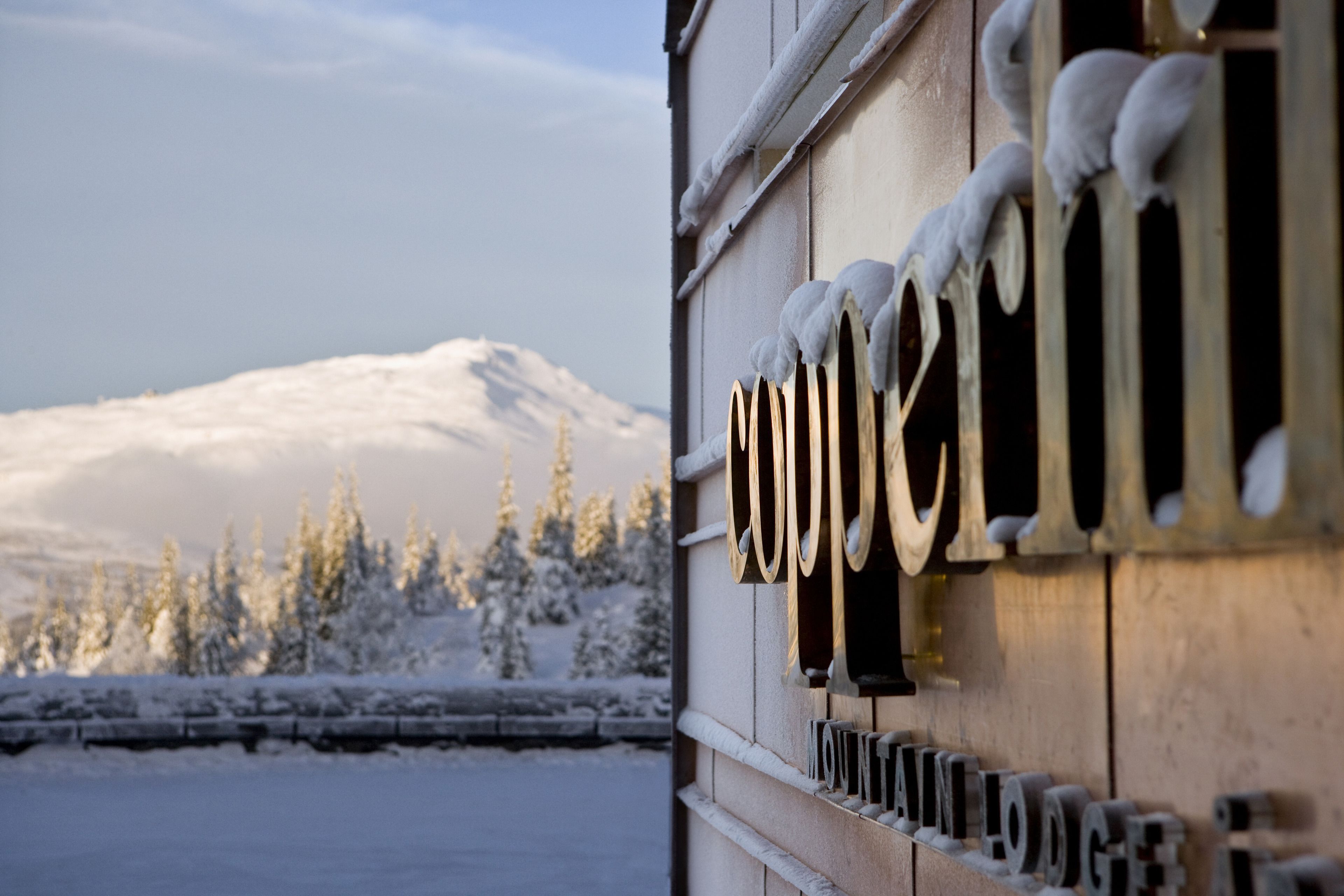 A wooden building with a snow-covered mountain in the background.