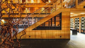 A multi-level wooden interior with a staircase, glass display cases, and a modern design.