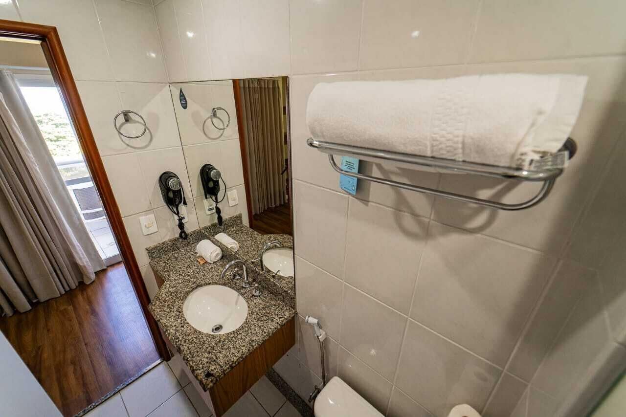 Ein Badezimmer mit zwei Waschbecken, einer Toilette, einem Handtuchhalter und einem Spiegel.