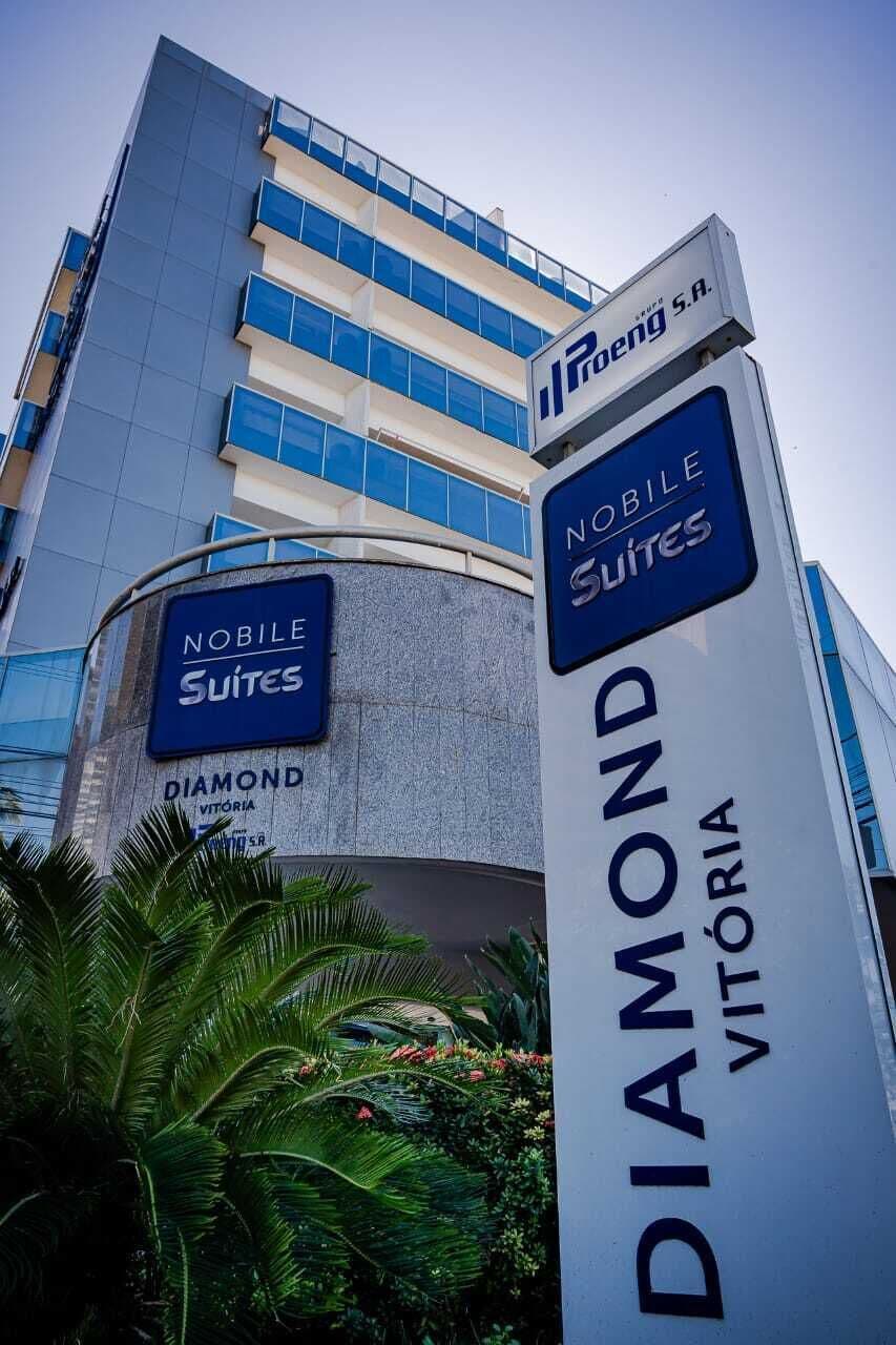 Placa de hotel com a marcação 'Noble Suites' e 'Diamond Vitoria', indicando um hotel com várias suítes e um nome que sugere uma localização privilegiada.