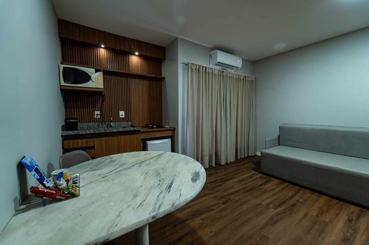 Un espacio habitable pequeño con kitchenette, un sofá y una mesa de comedor.