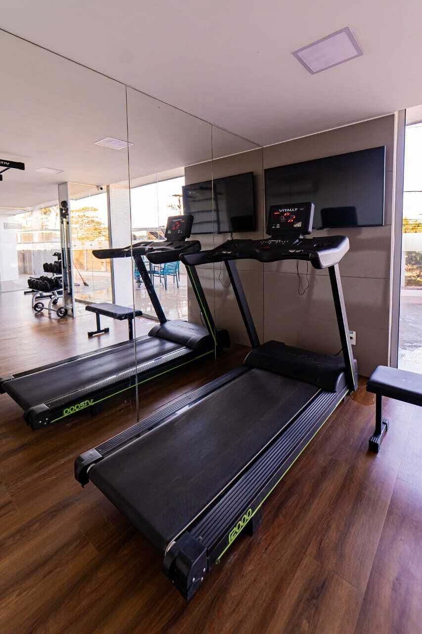 A gym with treadmills, a bench, and a weight bench.