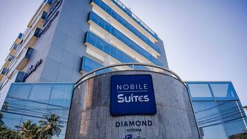 Un moderno edificio de hotel con un letrero que dice 'NOBLE SUITES' y 'DIAMOND VITORIA'.