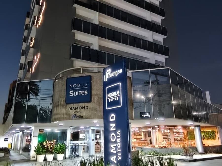 Un hotel con fachada moderna, un letrero que dice 'Noble Suites' y un letrero 'Diamond' que indica una ubicación privilegiada.