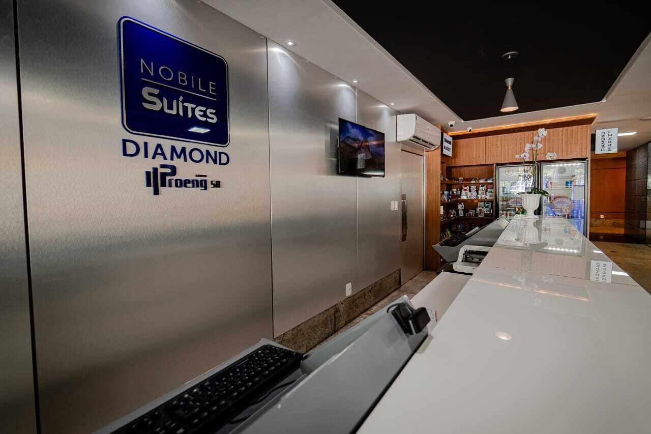 Zona de recepción de un hotel con un letrero que dice 'Noble Suites Diamond' y un letrero que indica 'Diamond Market'.