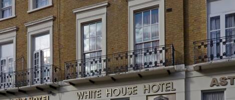 A multi-story hotel with a classic facade, featuring a prominent "WHITE HOUSE HOTEL" sign.