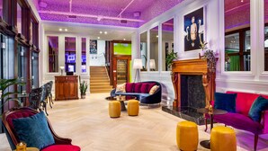 A spacious lobby with a grand staircase, plush seating, and a fireplace.