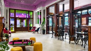 A spacious lobby with a high ceiling, large windows, and a mix of modern and classic furniture.