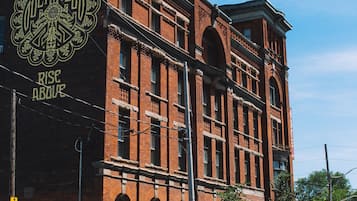 A historic brick building with a large sign reading "RICE HOUSE" and "RISE ABOVE".