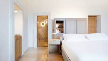 Un dormitorio moderno con una cama grande, una mesita de noche, un armario de madera y un estante empotrado con una lámpara.
