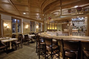 A restaurant with wooden interiors, bar area, and dining tables with chairs. - Hotel zum Erdinger Weissbräu (Erding)