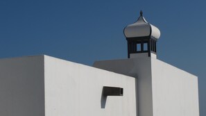 A building with a white facade and a distinctive black and white dome-shaped structure on top.