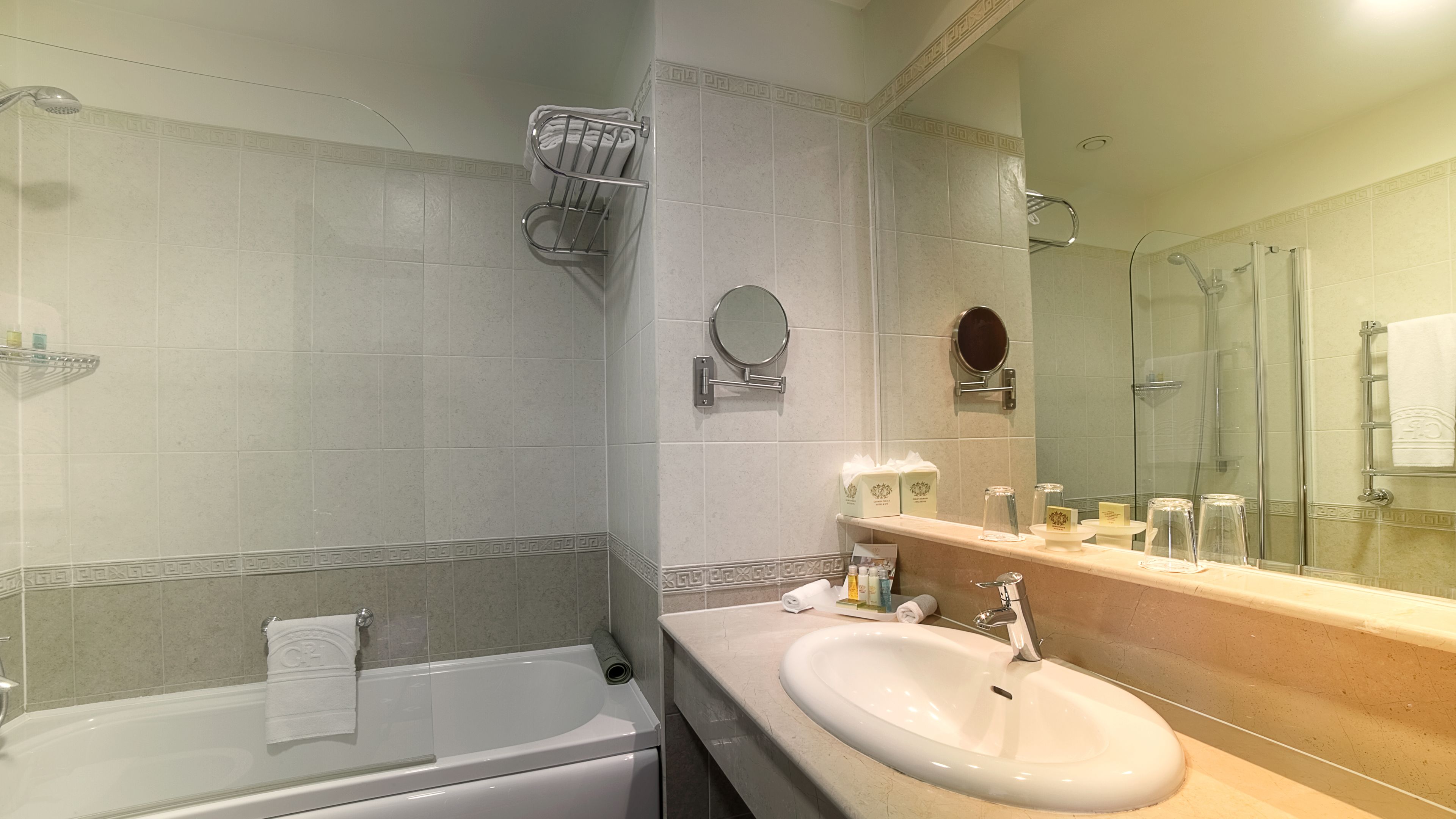 A modern bathroom with a bathtub, a sink, and a large mirror.