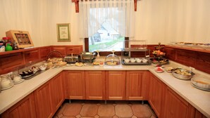 A kitchen with wooden cabinets, a breakfast bar, and various food items displayed on the counter.
