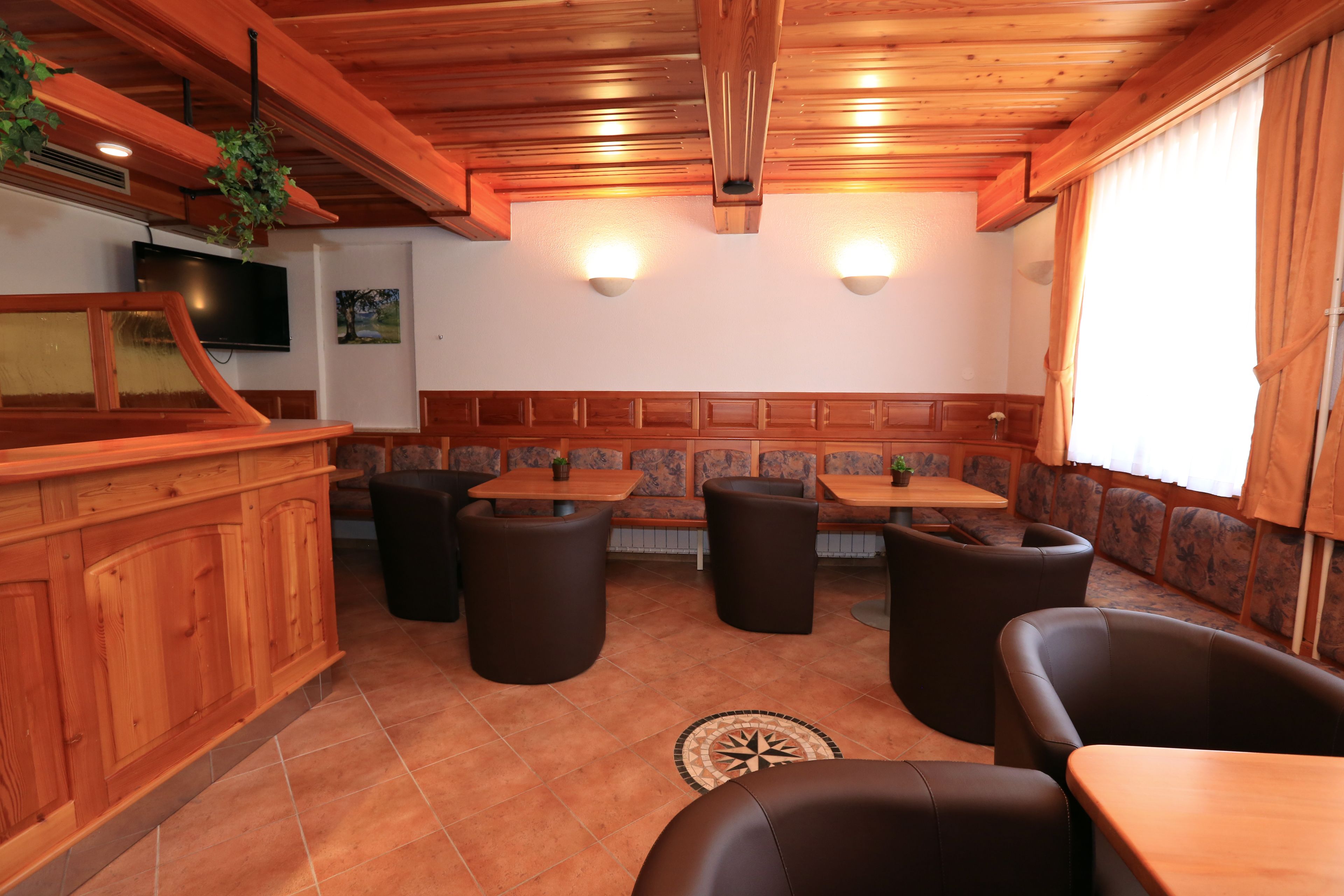 A wooden interior with seating and a bar area.