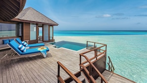 An overwater bungalows with wooden deck, infinity pool, and ocean views.