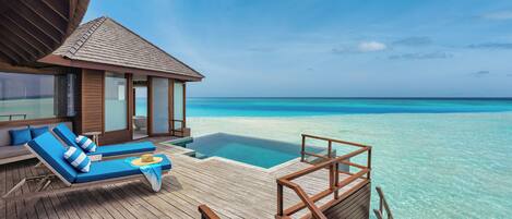 An overwater bungalows with wooden deck, infinity pool, and ocean views.
