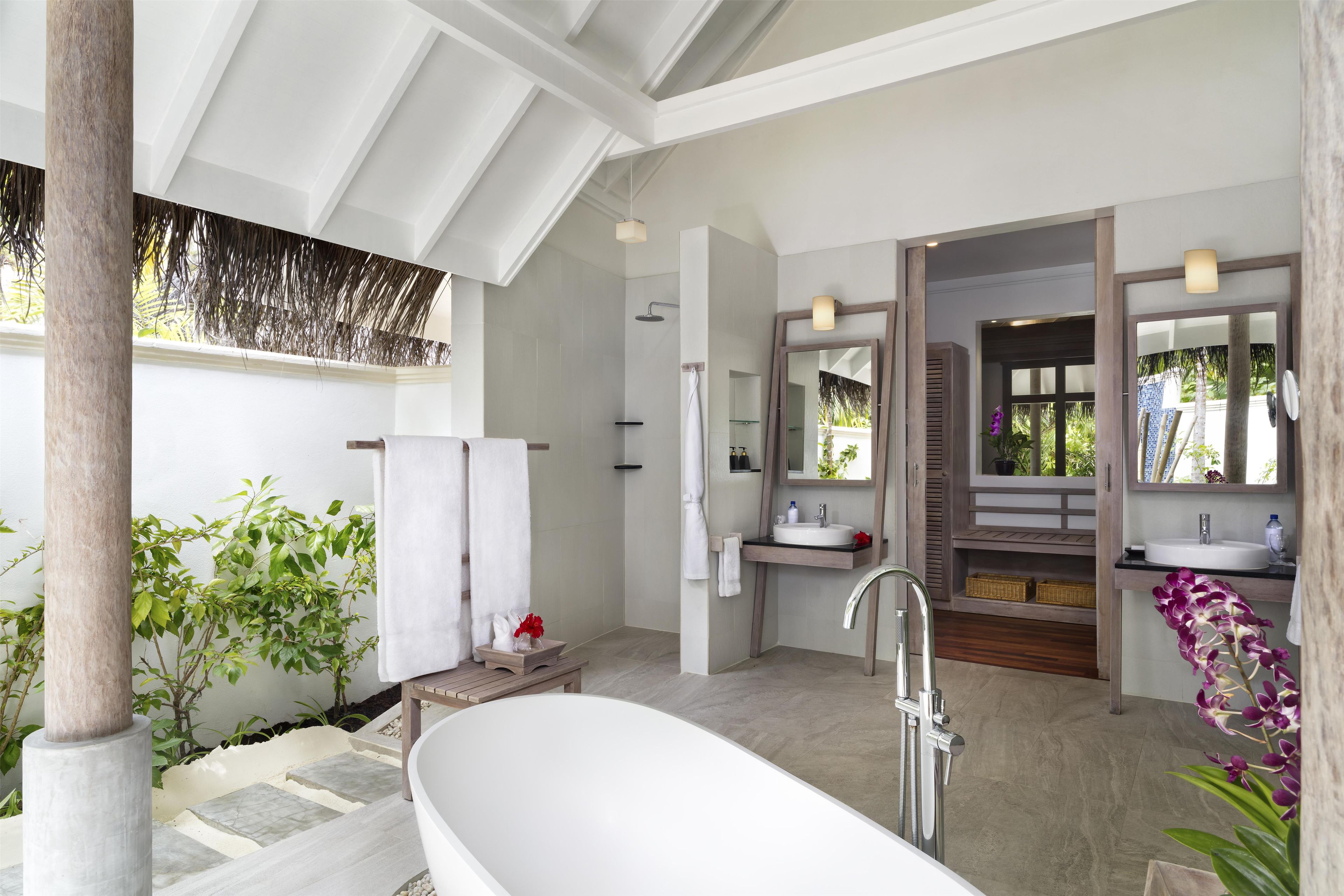 Un baño moderno con una bañera independiente, una ducha y un tocador con espejo.