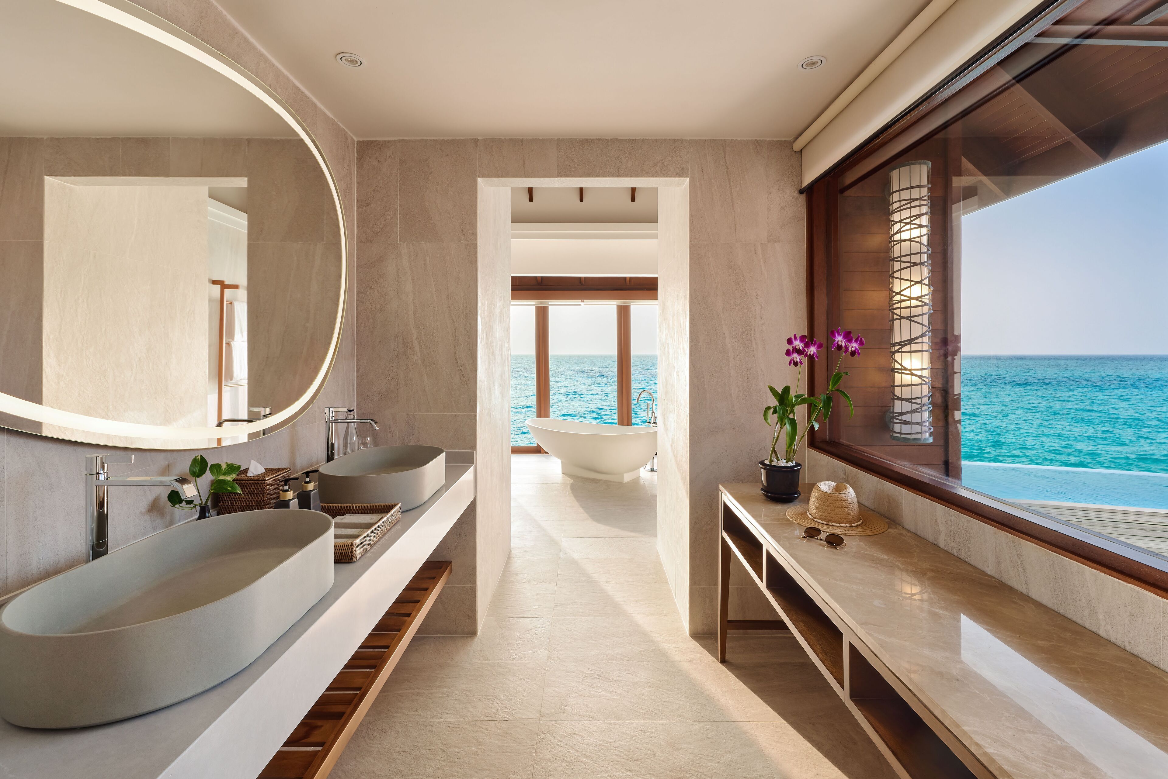 A modern bathroom with a large oval sink, a freestanding bathtub, and a large mirror.