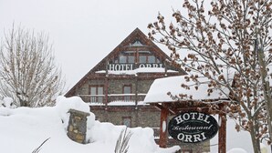 Un edificio cubierto de nieve con un letrero que dice "HOTEL ORRI Restaurant".