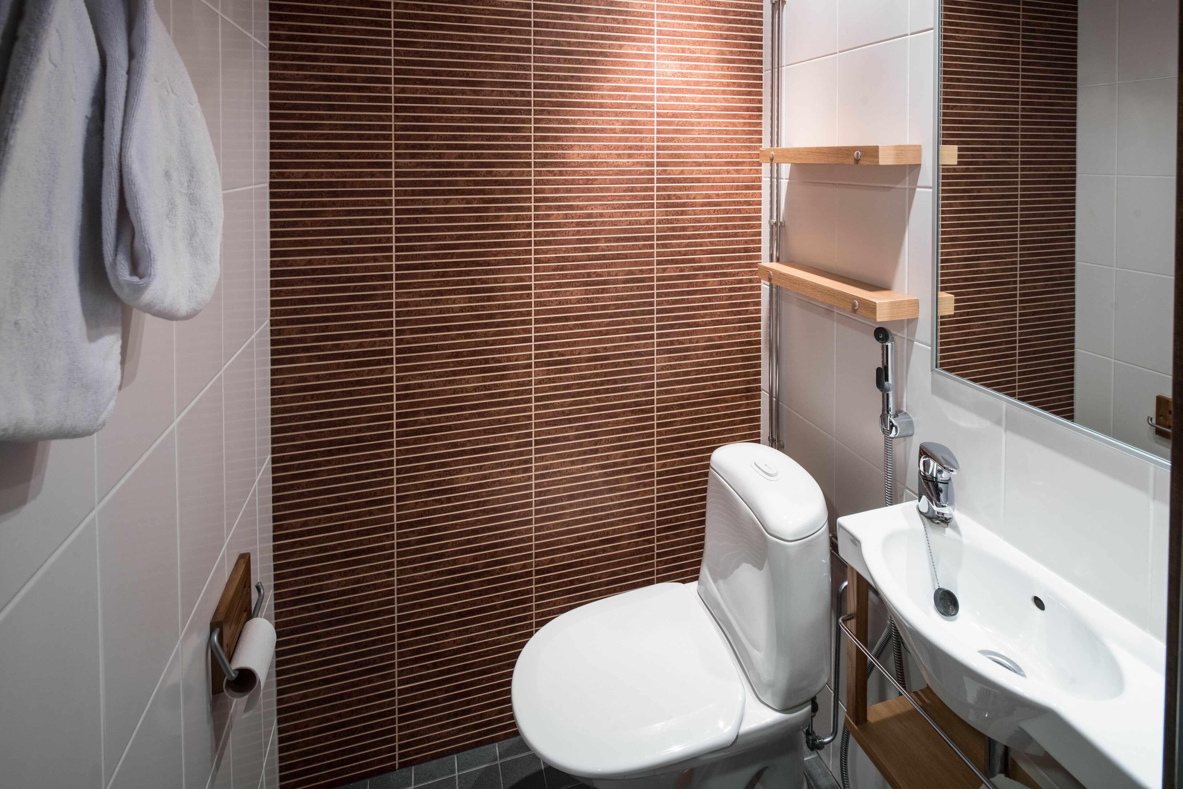 Un baño moderno con inodoro, lavamanos y toallero.