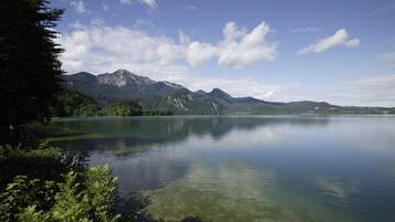A serene lake with mountains in the background and clear water reflecting the sky.