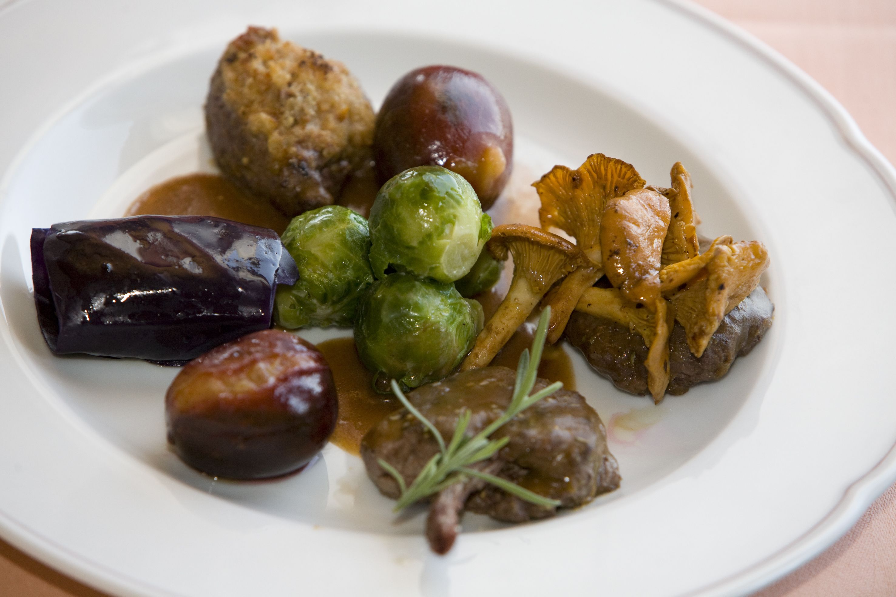 A plate of food with Brussels sprouts, mushrooms, and a meat dish.