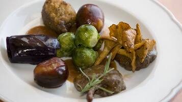 A plate of food with Brussels sprouts, mushrooms, and a meat dish.