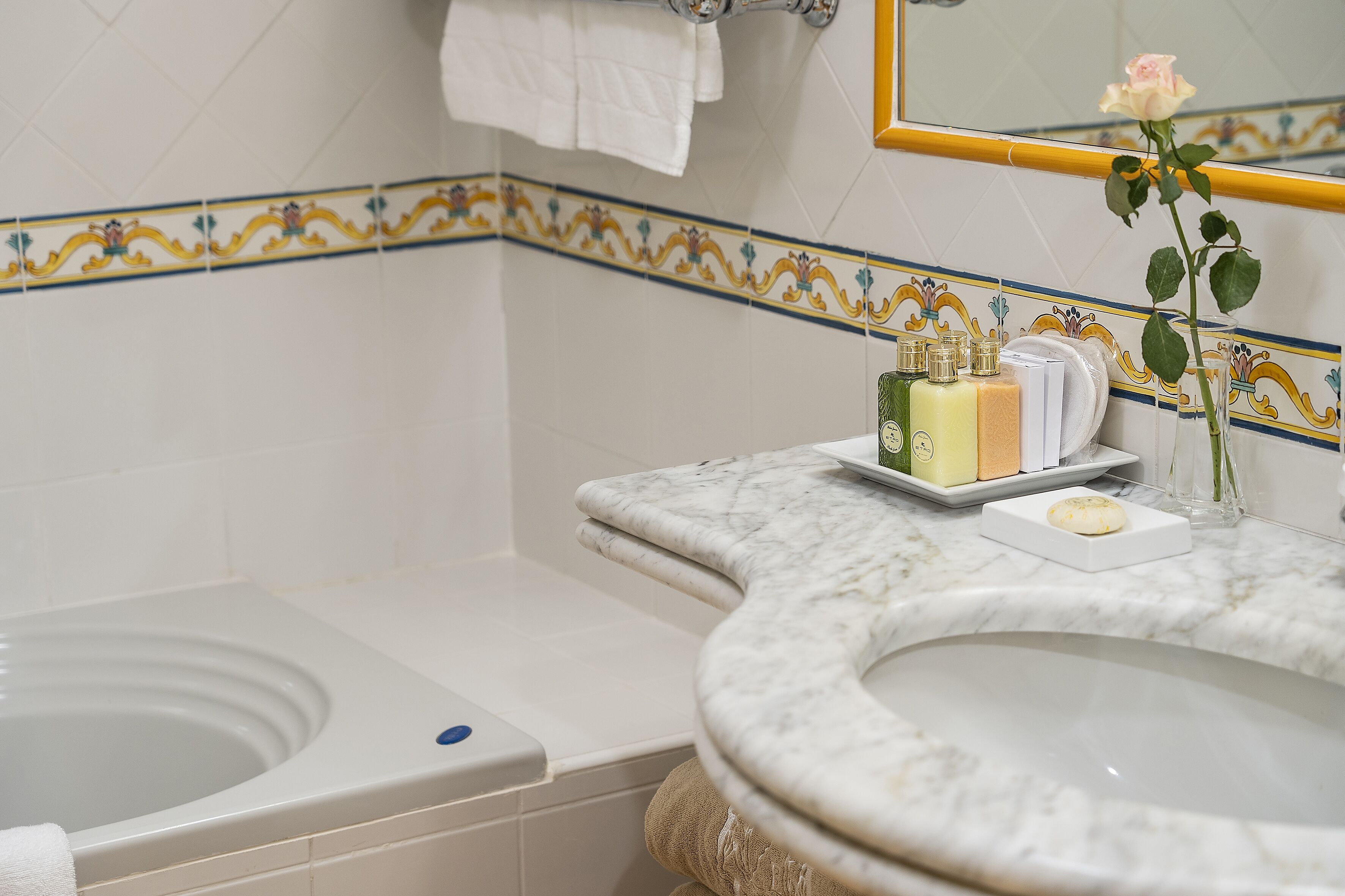 A bathroom with a bathtub, a sink, and a mirror.