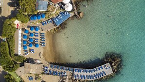 An aerial view of a beachside resort with multiple sun loungers, umbrellas, and a wooden deck overlooking the sea. - Excelsior Belvedere Hotel & Spa (Ischia)