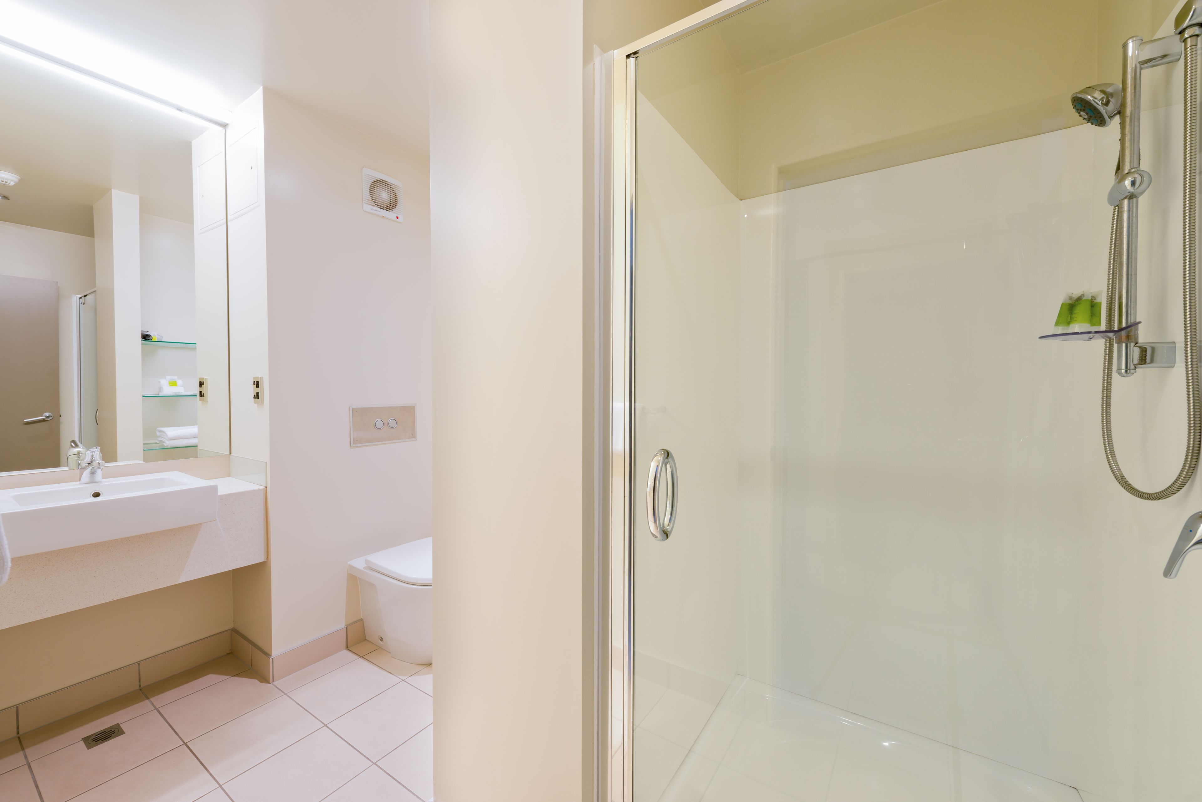 A modern bathroom with a glass-enclosed shower, a white sink, and a toilet.