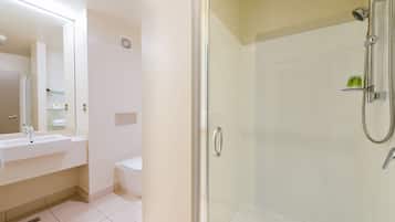 A modern bathroom with a glass-enclosed shower, a white sink, and a toilet.