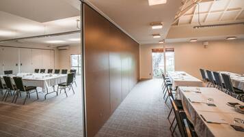 A conference room with a long table, chairs, and a partition wall.
