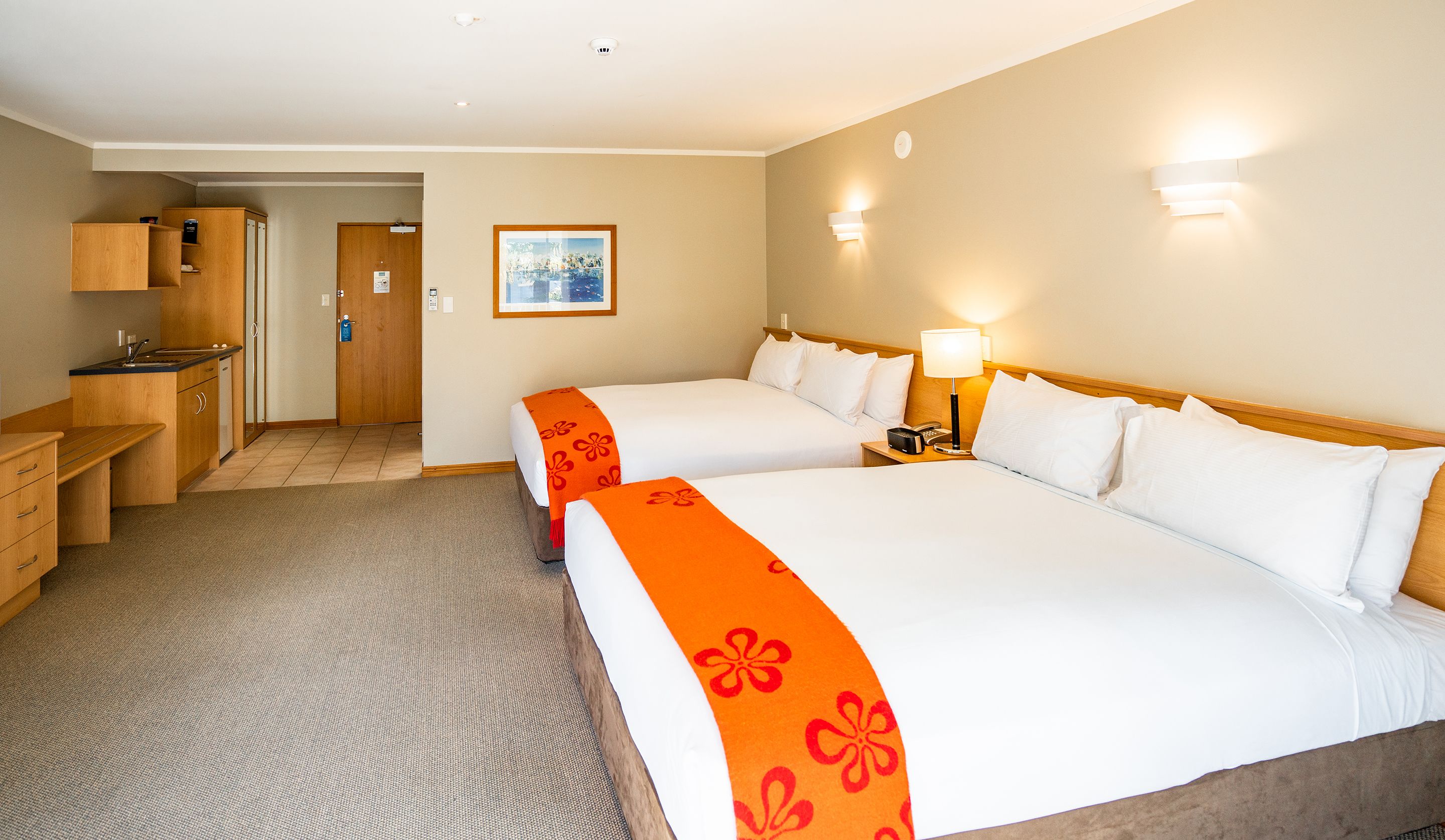 Une chambre d’hôtel avec deux lits, une petite kitchenette et une salle de bain.