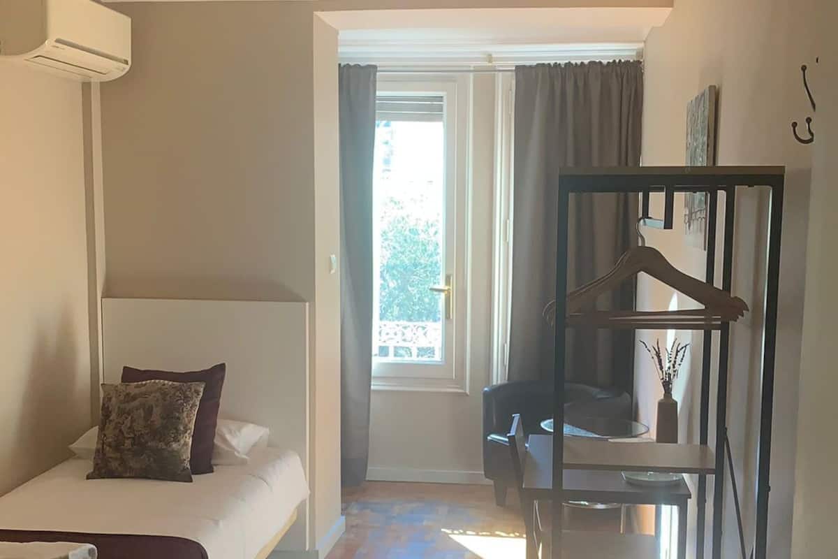 A room with a bed, a desk, and a window.