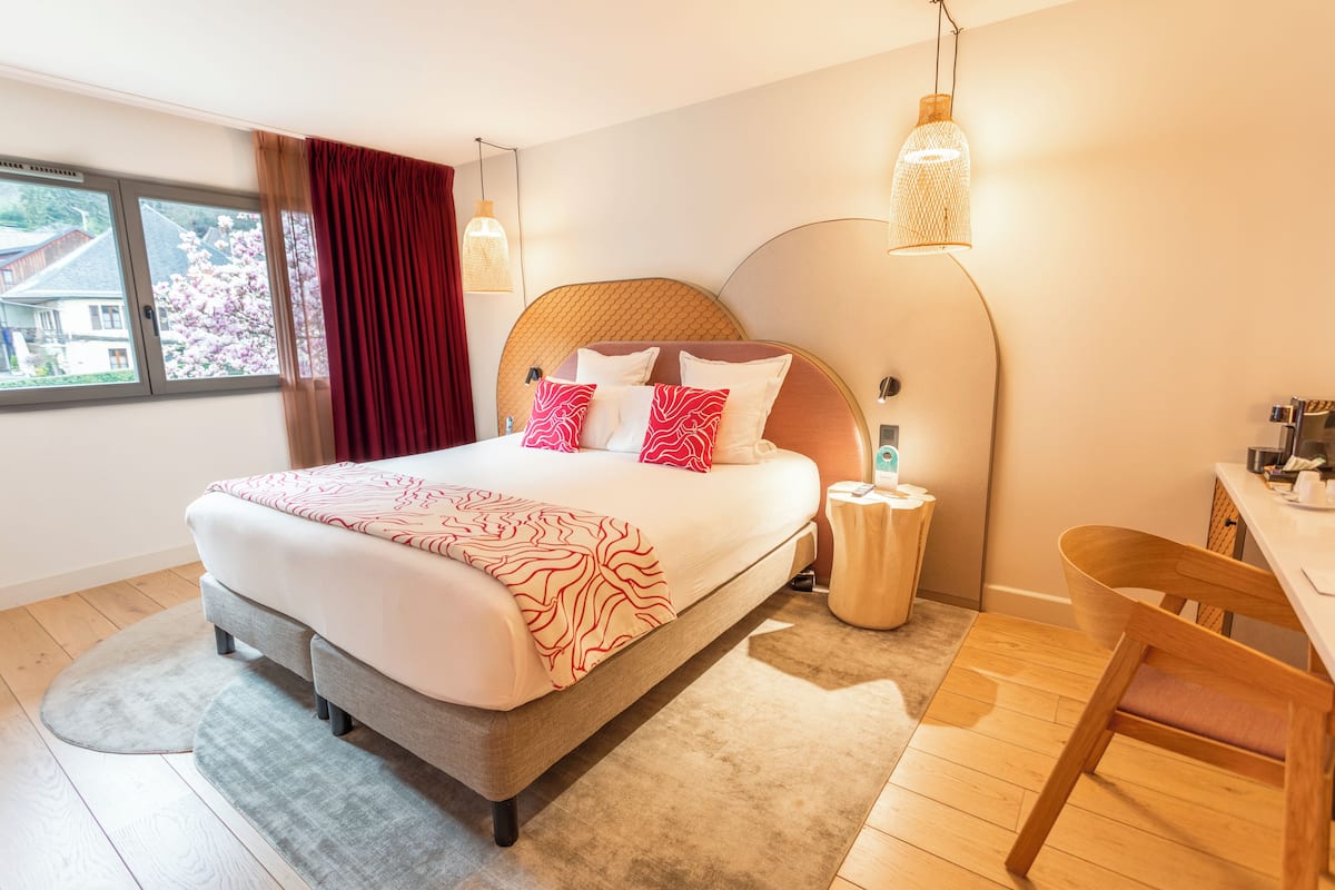 Une chambre moderne avec un grand lit, un bureau et une chaise.
