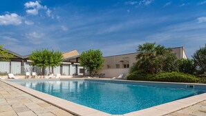 A swimming pool with lounge chairs and a building in the background. - KYRIAD PRESTIGE BEAUNE - Le Panorama (Beaune)