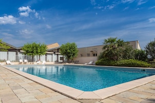 Una piscina al aire libre de temporada, sillones reclinables de piscina