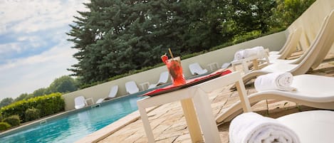 Piscine extérieure en saison, chaises longues