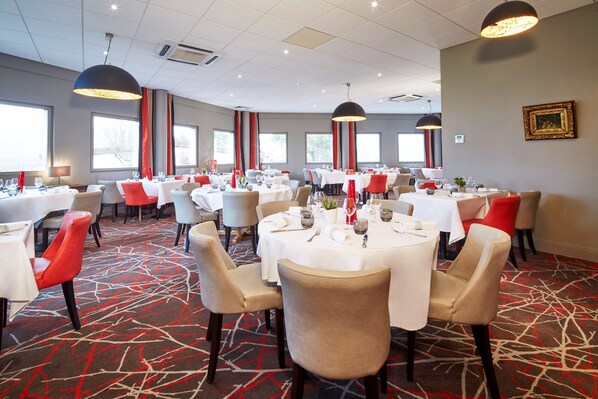 A conference room with round tables, chairs, and red accents. - KYRIAD PRESTIGE BEAUNE - Le Panorama (Beaune)