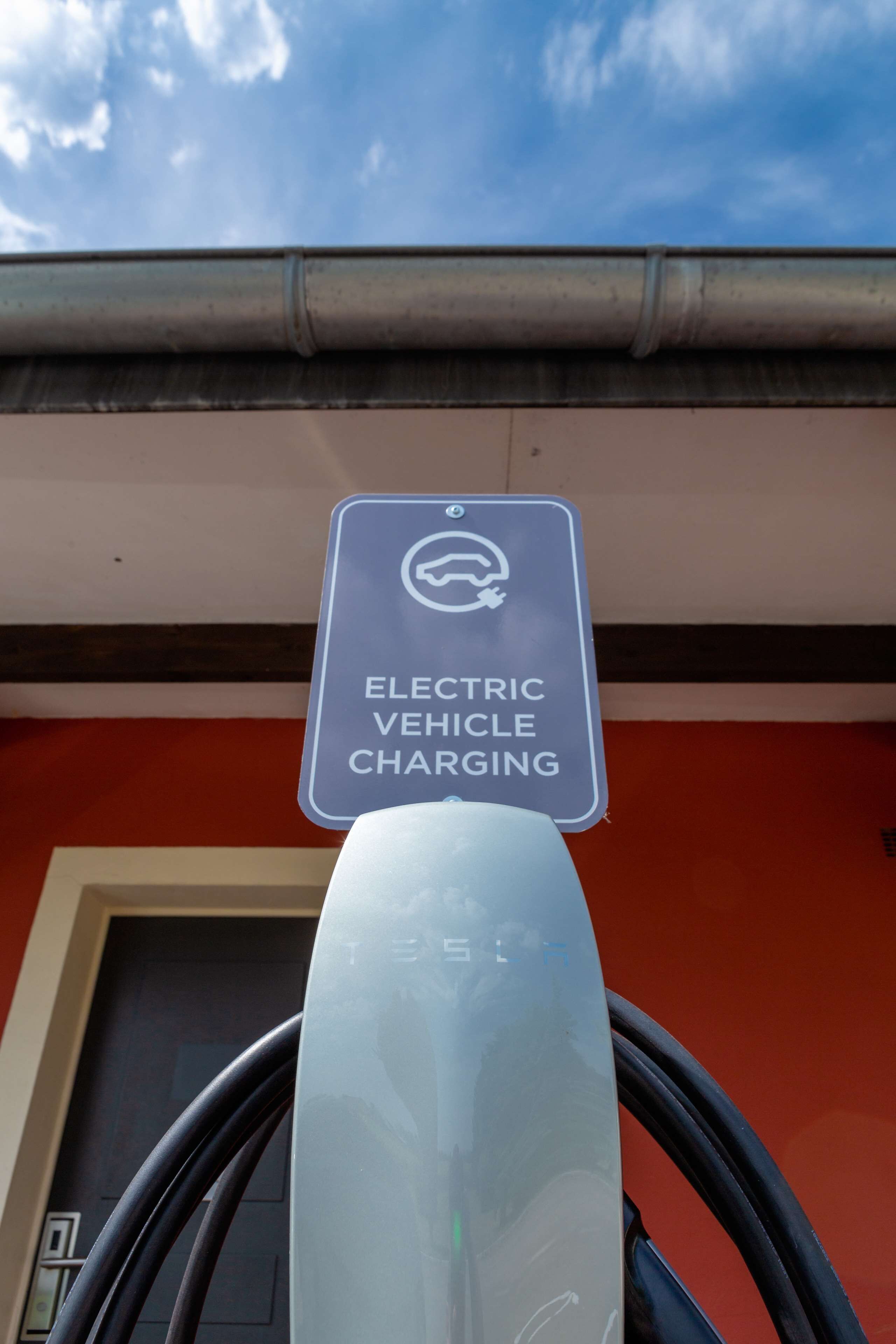 Una estación de carga para vehículos eléctricos, con un cartel que indica que es exclusiva para vehículos eléctricos.