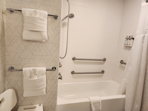 A bathroom with a bathtub, a shower, and two towel racks.